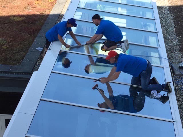 Montageteam brengt folie aan op een glazen dakconstructie