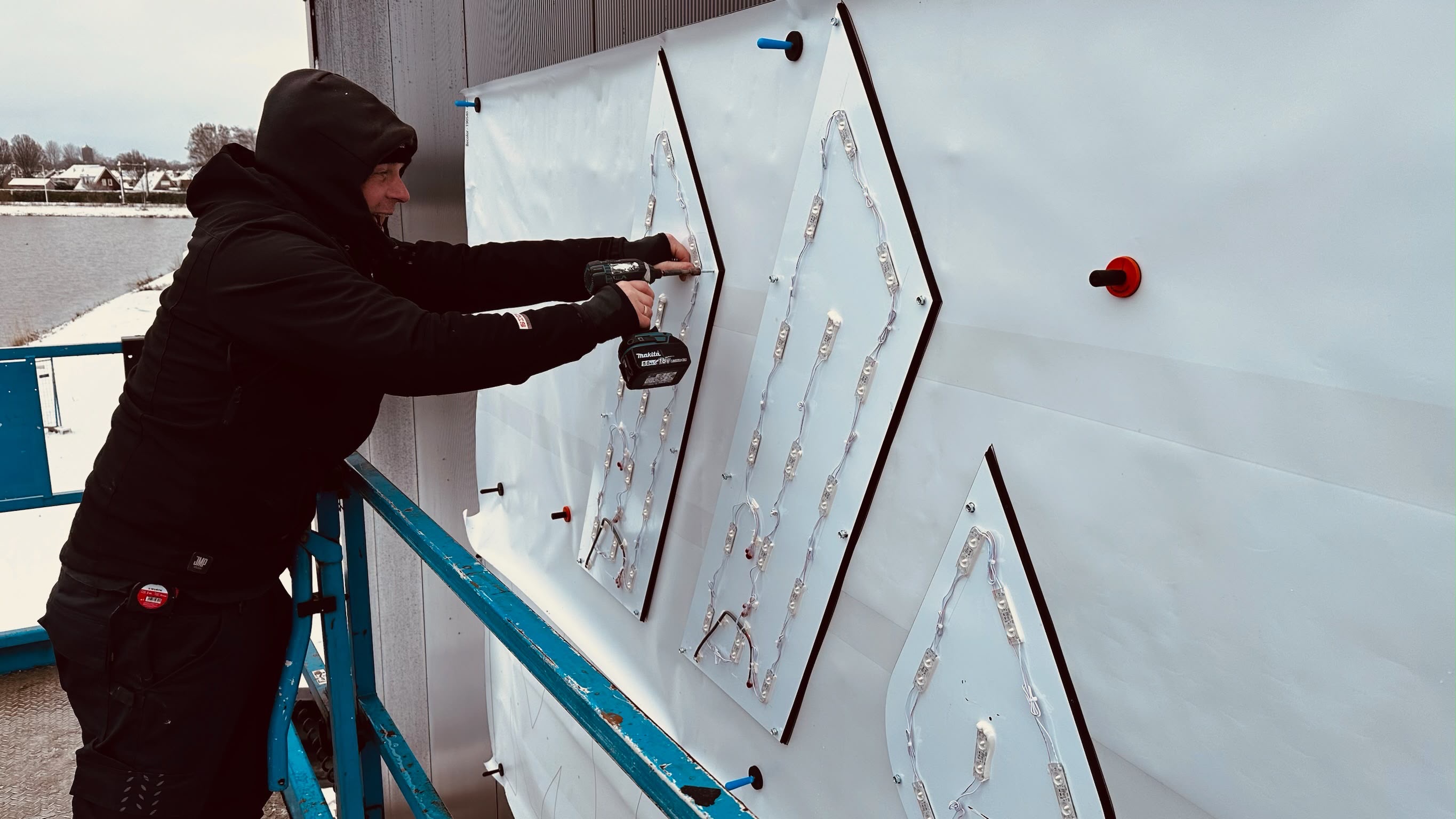 Montage van verlichte gevelletters in winterse omstandigheden