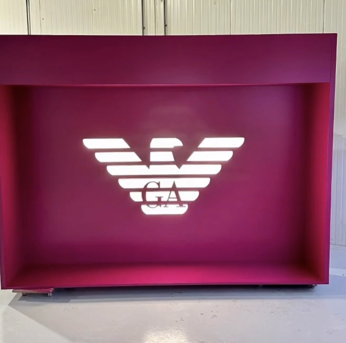 Magenta displaywand met gemonteerd verlicht logo